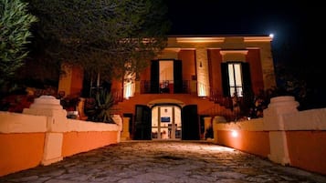 Un bâtiment doté d’une entrée en pierre, d’un balcon et d’un escalier menant à l’étage supérieur.