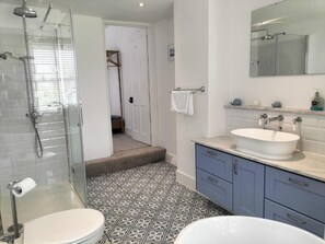 Bathroom features a bathtub, glass-enclosed shower, and a white toilet.