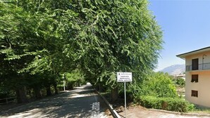 A road lined with trees and a building with balconies. - B&B Residence Armonia Sulmona, city center (Sulmona)