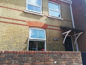 A two-story brick building with a sign reading "SEAGULL'S PERCH" and a number "120" above the door. - Seagulls Perch (Cowes)