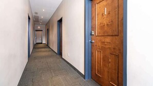 A hallway with carpeted floors, wooden doors, and a ceiling with recessed lighting. - Spacious Downtown Loft with AC (Halifax)