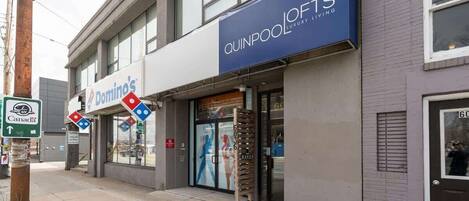 A building with a Domino's Pizza store and a Quipool Luxury Living sign.