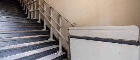 A staircase with a handrail and a white object on the right.
