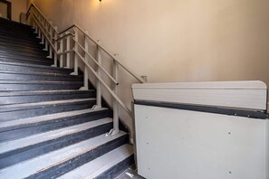 Eine Treppe mit Handlauf und einem weißen Gegenstand auf der rechten Seite.
