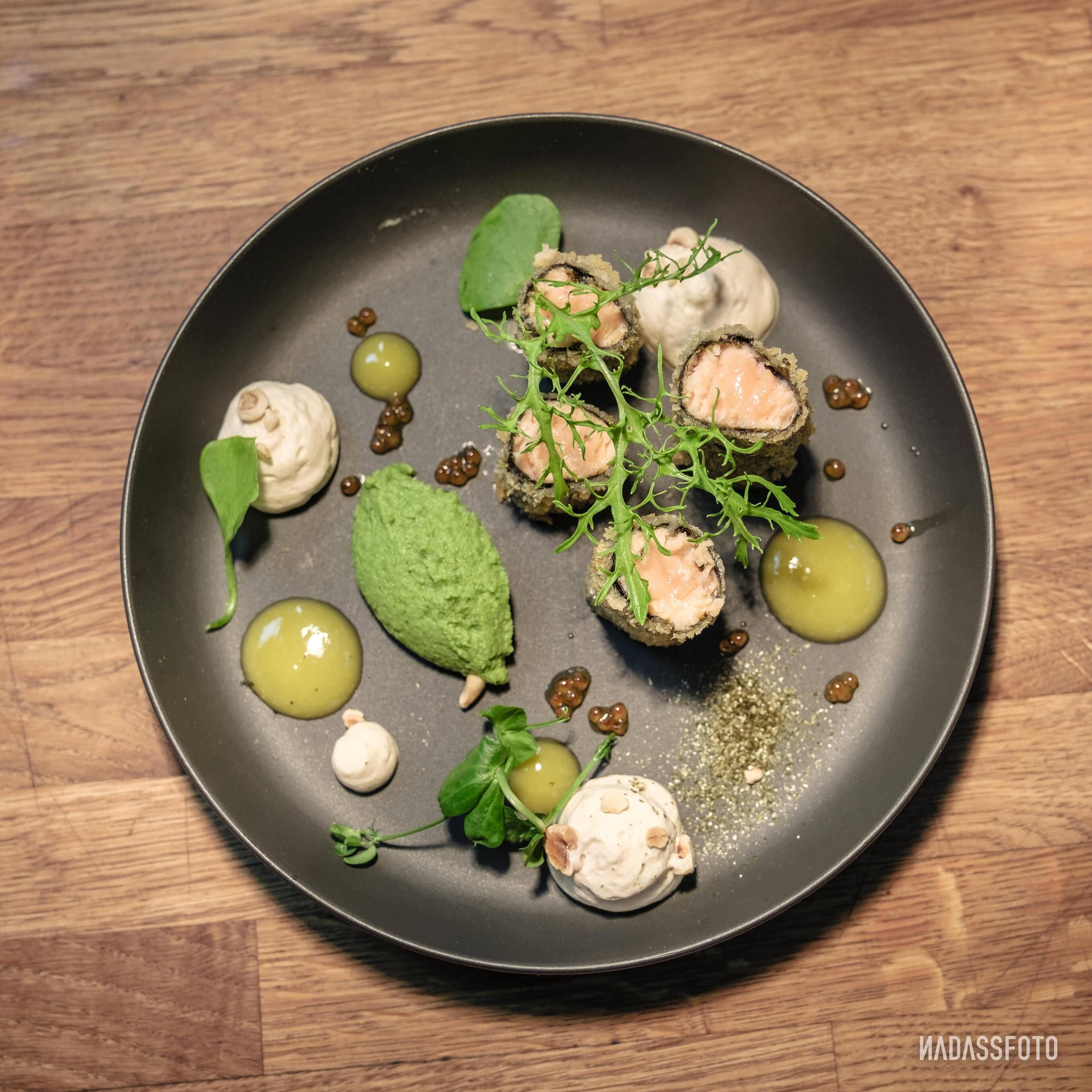 Un plato de sushi con diferentes guarniciones y salsas.