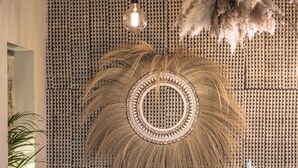 A dining area with a patterned wall, a central decorative element, and a hanging light fixture. - La Cambrousse (Villers-la-Chèvre)