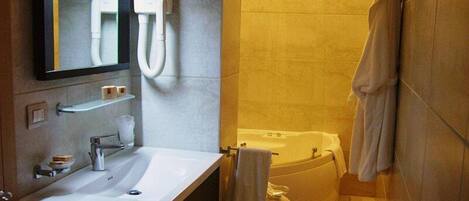 A modern bathroom with a sink, mirror, and bathtub.
