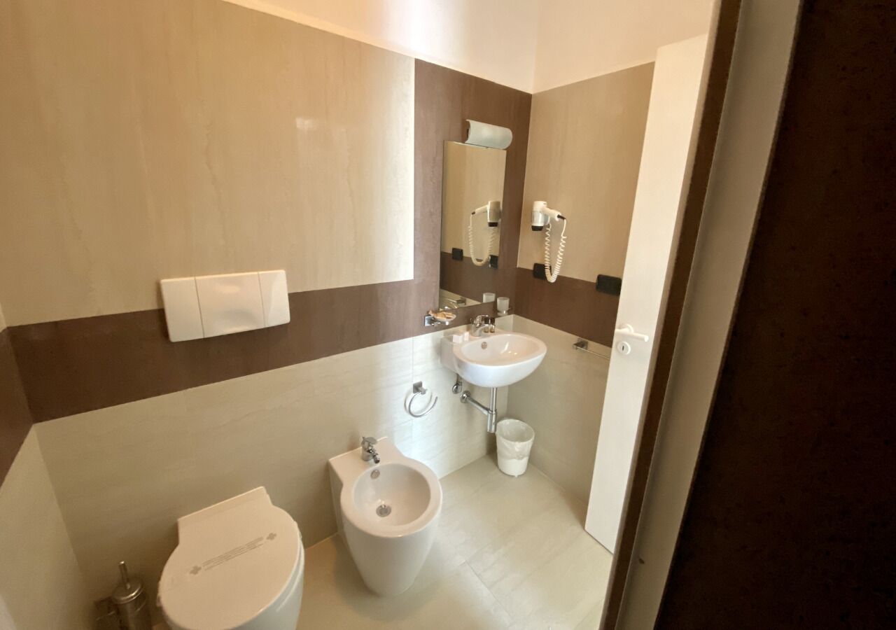 Un baño moderno con dos lavamanos, un bidé y un inodoro.