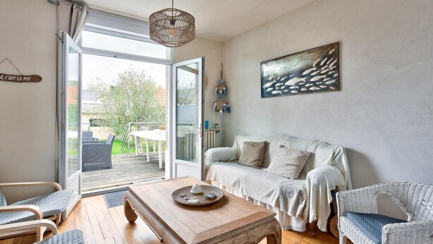 A cozy living room with a wooden coffee table, a white sofa, and wicker chairs. - Superb house for 6 people - close to the beach (Dinard)