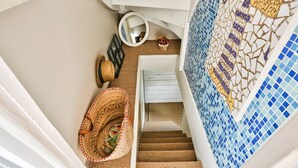 A staircase with a blue mosaic wall, a woven basket, and a mirror. - Superb house for 6 people - close to the beach (Dinard)