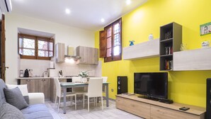 A compact living space with a dining area, kitchen, and seating area.