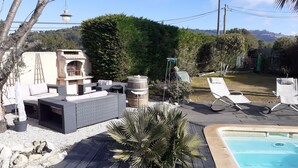A poolside area with outdoor furniture, a barbecue, and a view of the hills. - Villa Les Palmiers, 15 minutes from Monaco, Nice and the seaside. (Èze)