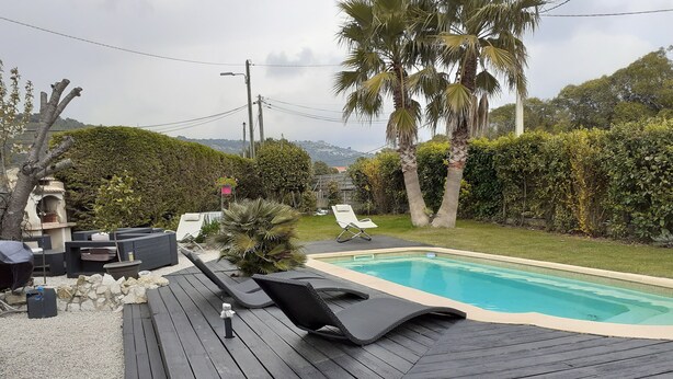 A wooden deck with a pool, lounge chairs, and a small garden area with palm trees and shrubs. - Villa Les Palmiers, 15 minutes from Monaco, Nice and the seaside. (Èze)