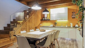 A modern kitchen with wooden cabinetry, a built-in stove, and a large window. - Domu Mea - Morada - Two Bedroom House, Sleeps 4 (Iglesias)
