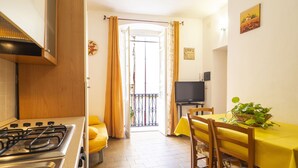 Une cuisine équipée d’une cuisinière, de chaises jaunes et d’une table à manger recouverte d’une nappe jaune.
