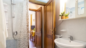 Une salle de bain avec une douche, un lavabo et des portes en bois.