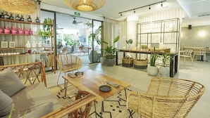 A modern interior with a wooden dining table, wicker chairs, and a variety of potted plants. - Brand new luxury studio condo,with private pool in Tuk  (Tulum)