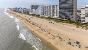 Uma praia com edifícios altos ao fundo.