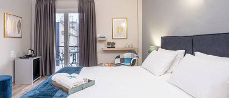 A hotel room with a large bed, a desk, a chair, and a view of the outdoors.