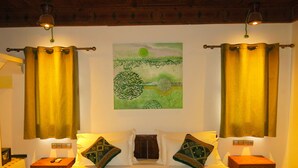 A hotel room with a bed, two nightstands, a wall-mounted painting, and curtains. - Desert Villa Boutique Hotel Merzouga (Taouz)
