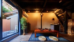 Una habitación japonesa tradicional con suelo de tatami, una mesa de madera baja y un biombó shoji.