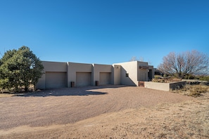A modern building with a gravel driveway and a few trees. - Private 10-Acre Estate & Mountain Views (Santa Fe)