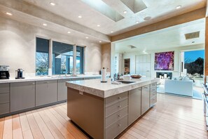 A modern kitchen with a large island, built-in appliances, and a view to the outdoors. - Private 10-Acre Estate & Mountain Views (Santa Fe)
