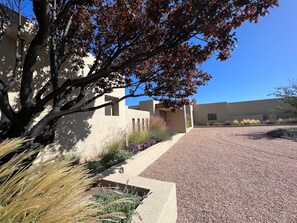 A building with a gravel driveway and a tree with autumn leaves. - Private 10-Acre Estate & Mountain Views (Santa Fe)