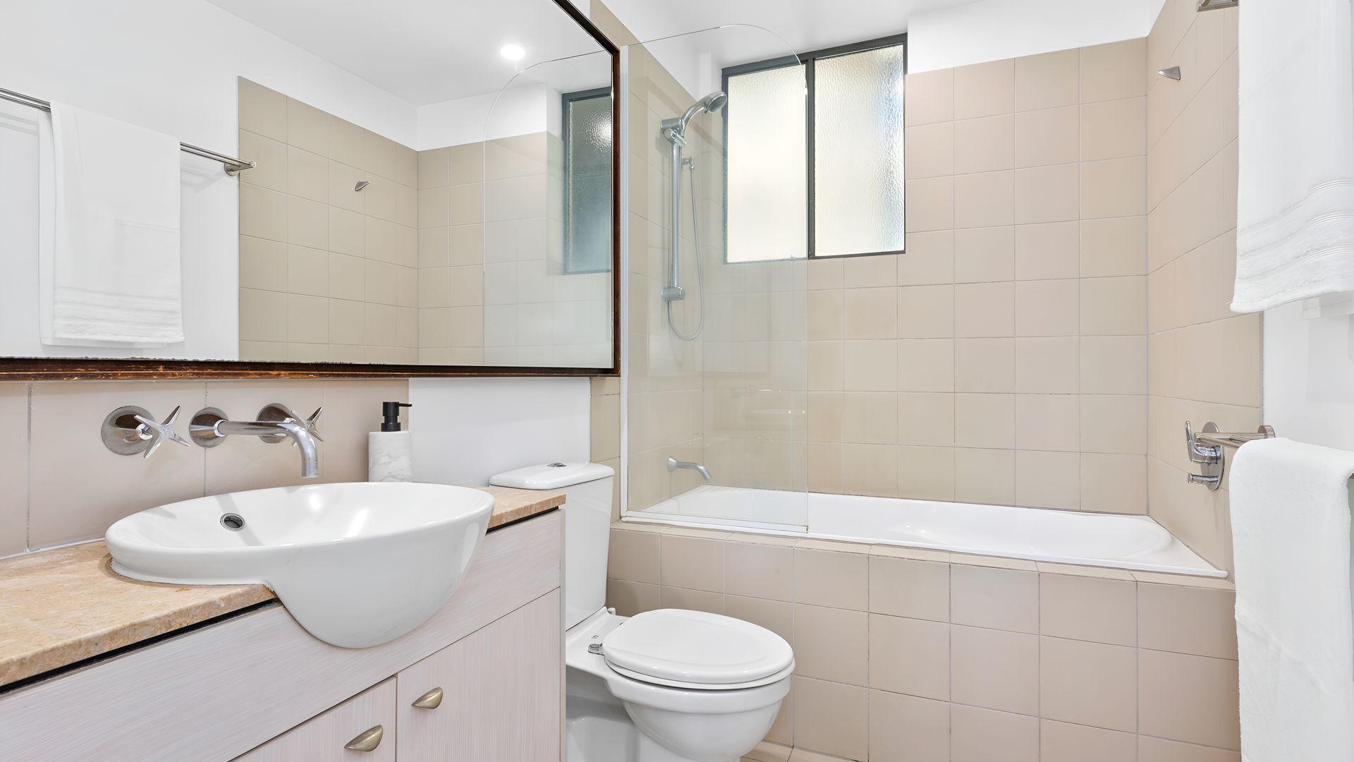A modern bathroom with a large sink, toilet, and bathtub.