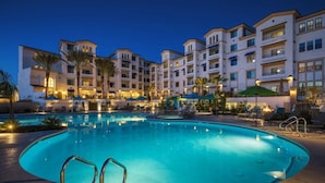 Ein Hotel mit großem Schwimmbad, mehreren Balkonen und Außenbereichen zum Sitzen.