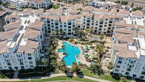 Ein Resort mit mehreren Gebäuden, einem zentralen Pool und umliegender Bepflanzung.