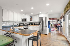 Enjoy cooking in this well-equipped kitchen with stainless steel appliances, ample counter space, and a central island with seating.