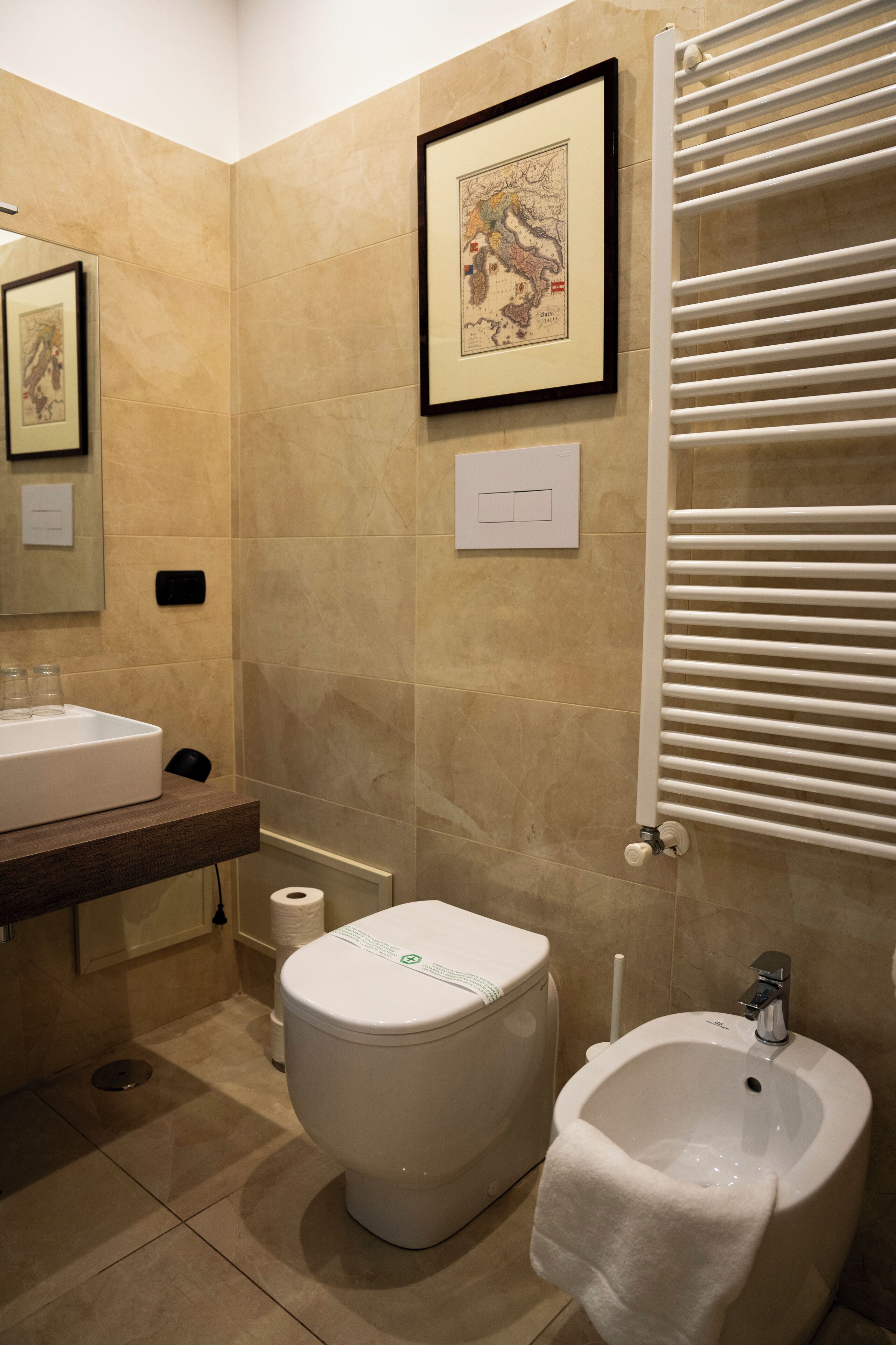 Ein Badezimmer mit Toilette, Bidet, Waschbecken und Handtuchhalter.