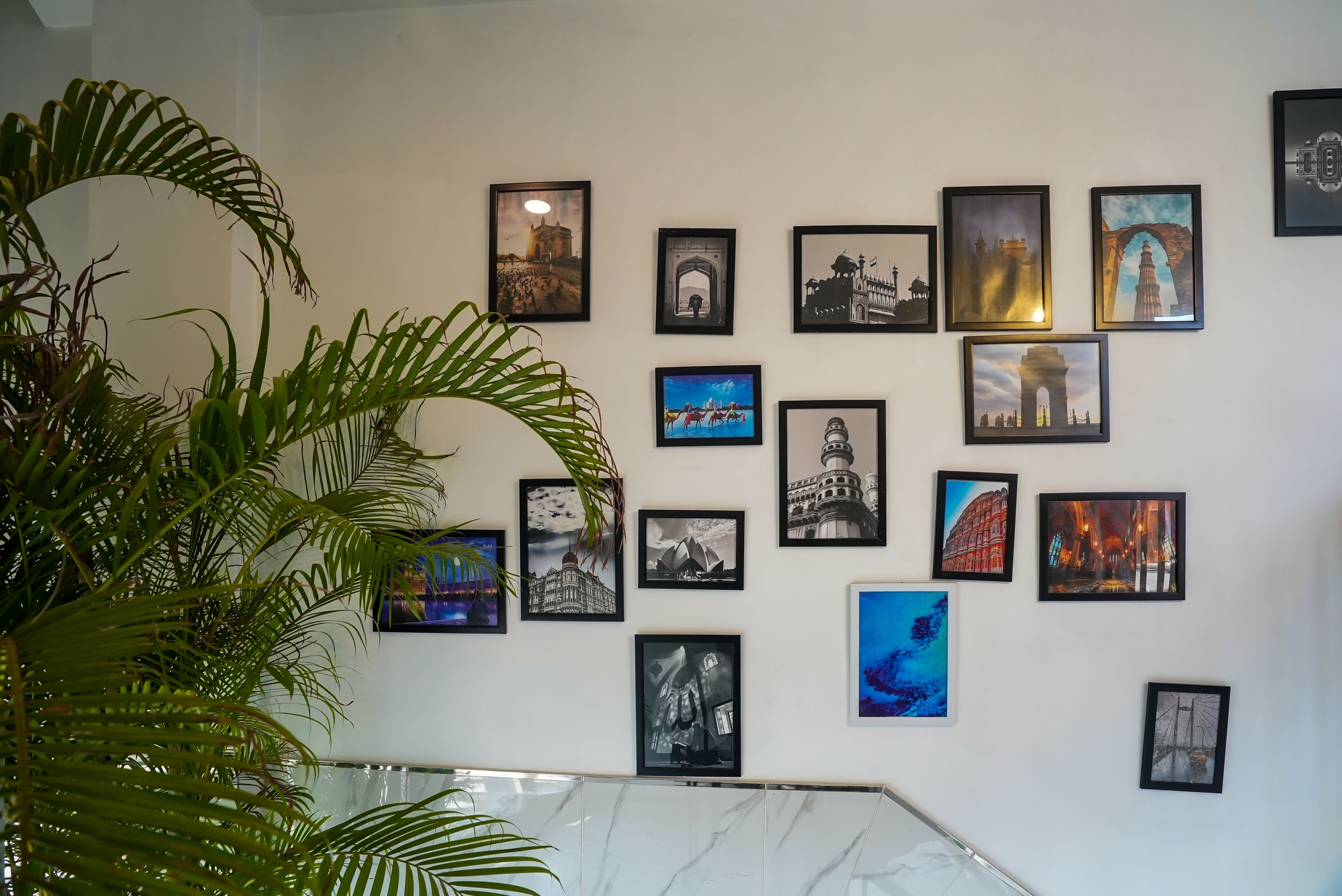 Una pared con varios cuadros enmarcados de monumentos famosos.