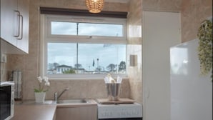 Una cocina moderna con ventana, pileta, estufa y refrigerador.