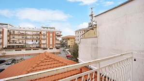 A residential building with balconies, a red-tiled roof, and a clear sky. - 'Ama' Apartment with Balcony, Wi-Fi, and Air Conditioning (Albenga)