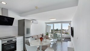 Eine moderne Küche mit Einbauofen, Kühlschrank und Flachbildfernseher.