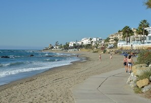 A beach with a concrete walkway, ocean waves, and buildings in the background. - Villa 'Casa Kasima' with Private Pool, Wi-Fi and Air Conditioning (Calahonda)