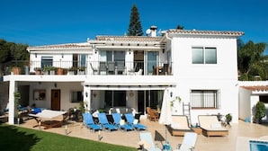 A two-story building with a pool, outdoor seating, and a balcony. - Villa 'Casa Kasima' with Private Pool, Wi-Fi and Air Conditioning (Calahonda)