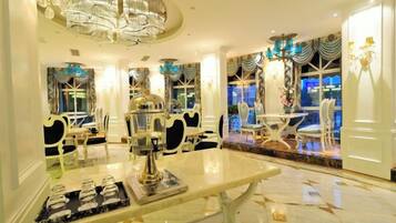 Un elegante comedor con candelabros, una mesa de mármol y sillas refinadas.