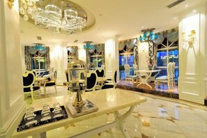 A luxurious dining area with chandeliers, a marble table, and elegant chairs. - Nanhu Garden Hotel (Guiyang)