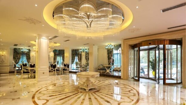 A luxurious lobby with a central circular marble floor, elegant chandeliers, and a glass entrance. - Nanhu Garden Hotel (Guiyang)