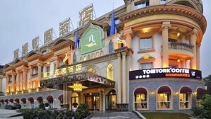 A hotel with a classic architectural style, featuring arched windows and a central entrance with a marquee. - Nanhu Garden Hotel (Guiyang)