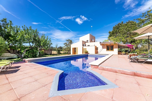 A swimming pool with a modern house in the background.