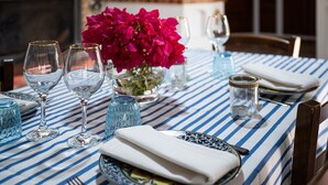 A table set with wine glasses, a folded napkin, and a plate with food.