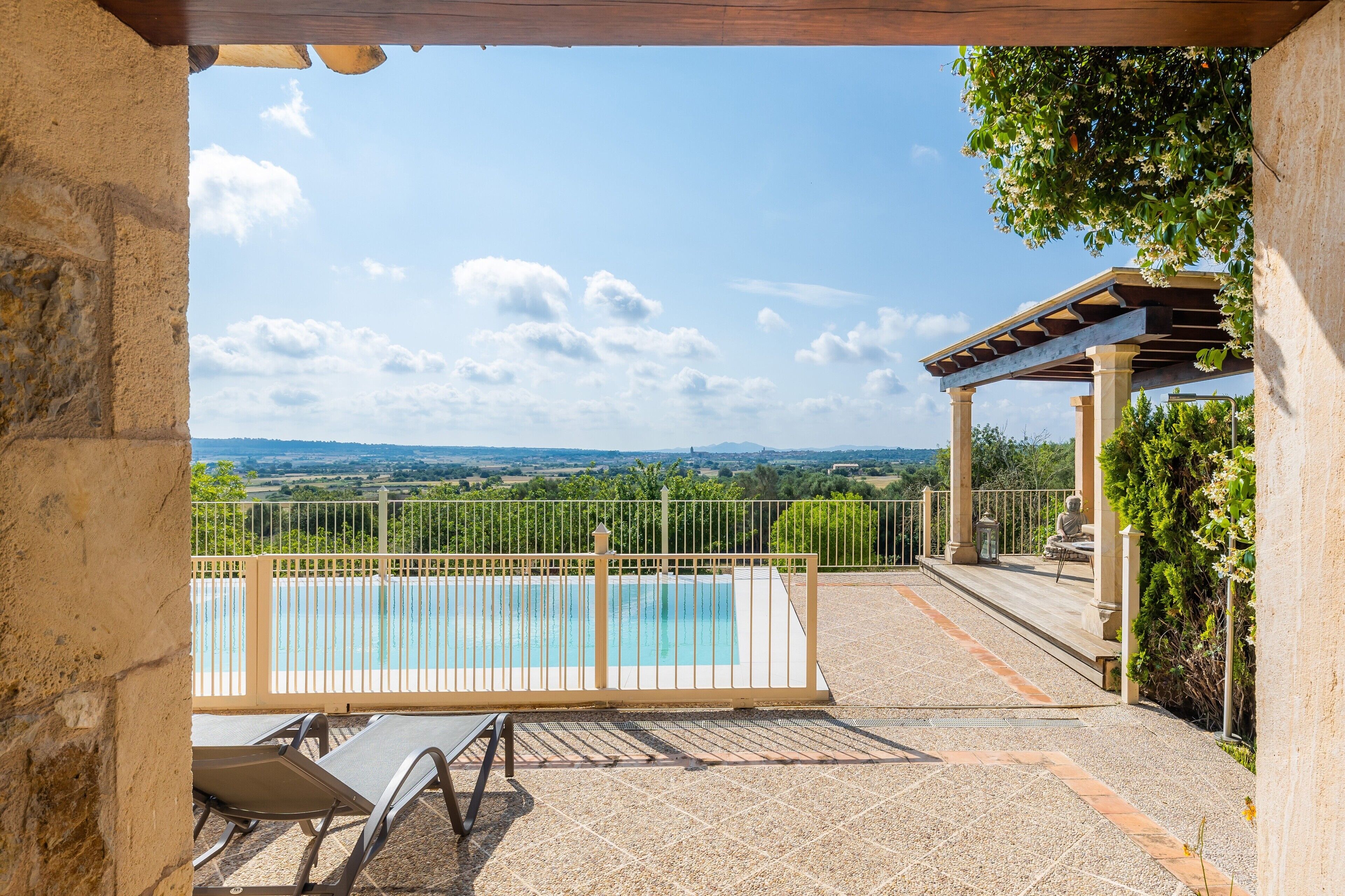 Area piscina con vista sul paesaggio, una pergola e un angolo relax.
