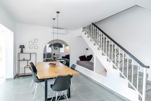 Una cocina moderna con comedor, escalera y sala de estar.