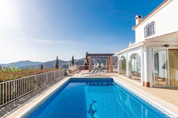 Una piscina con vistas despejadas a las montañas al fondo.