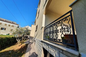 Enjoy the serene views from this building's balcony overlooking a tranquil pathway.