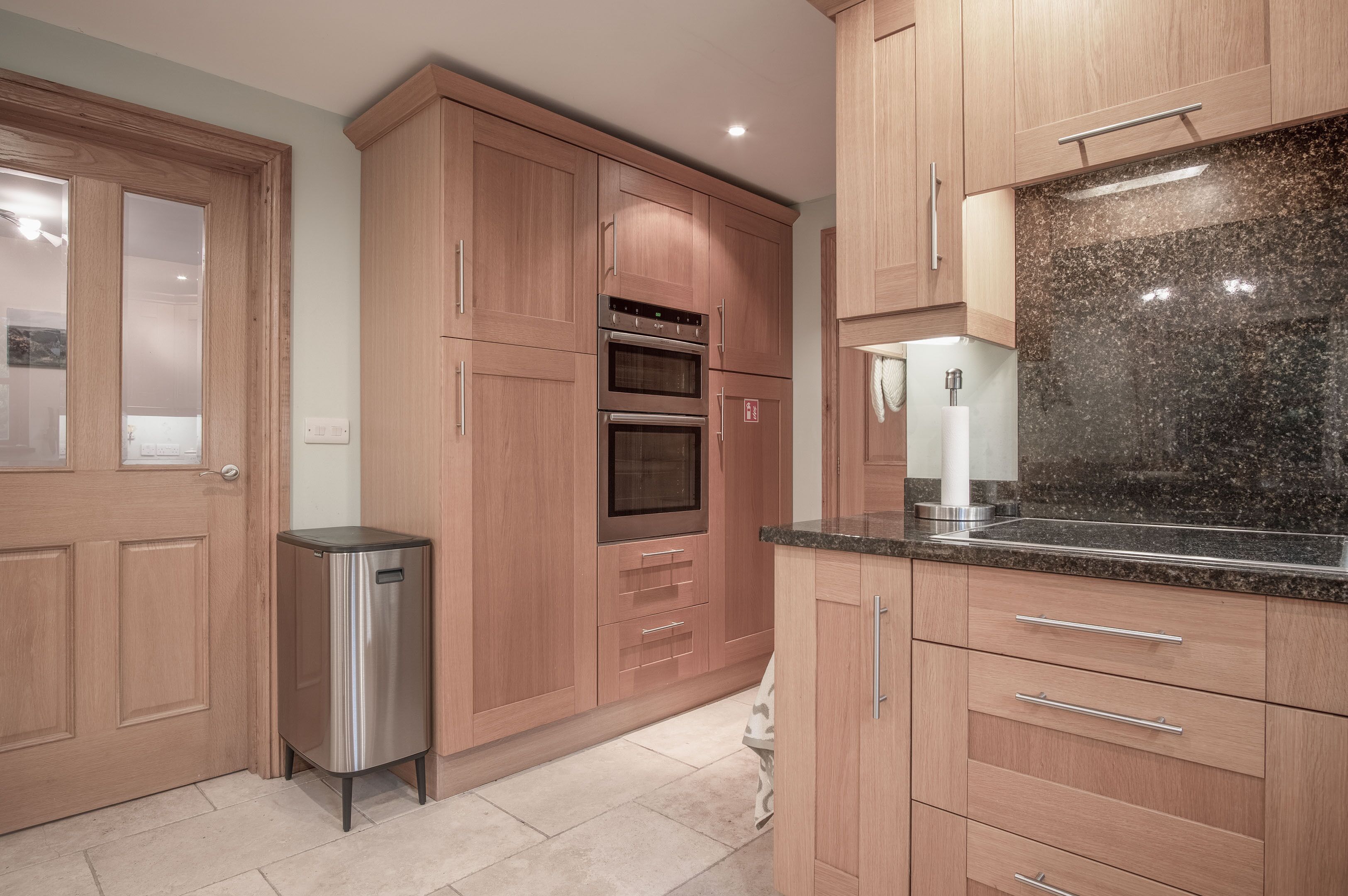 A kitchen with wooden cabinets, stainless steel appliances, and a granite countertop.